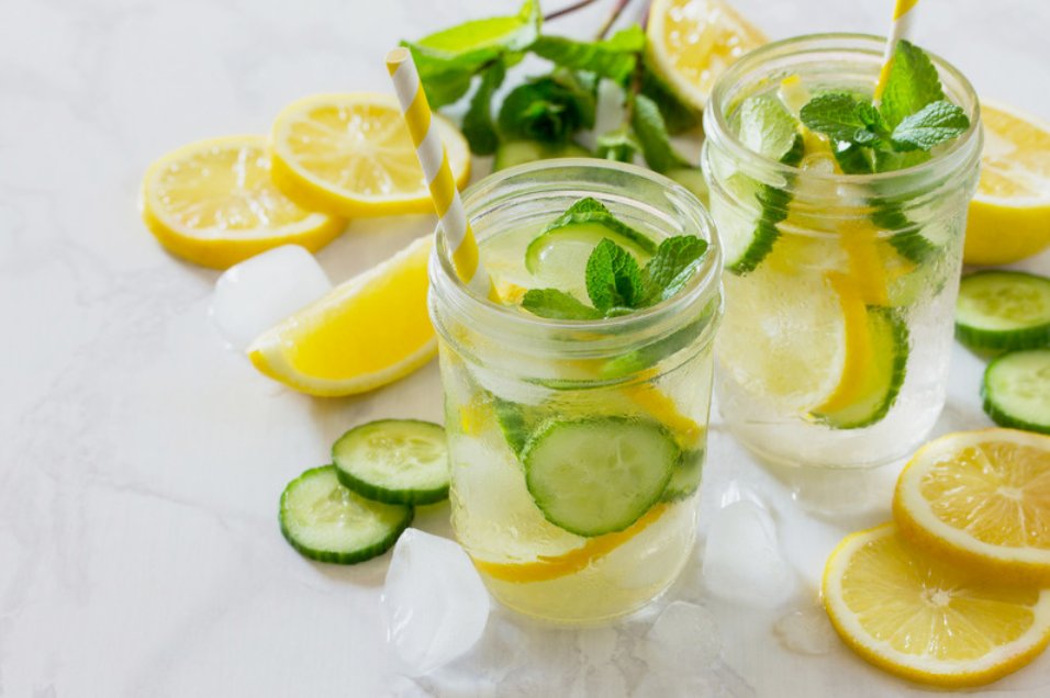 Zwei Gläser Wasser mit Zitronen- und Gurkenscheiben und frischer Minze