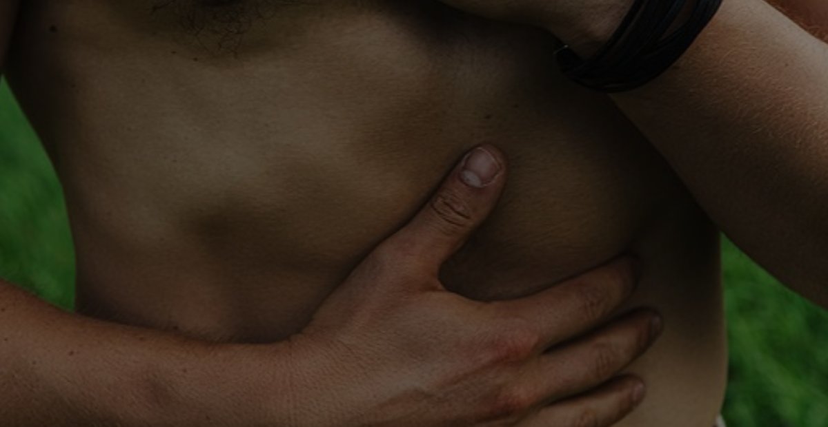 Tim legt eine Hand auf die Brust und eine auf den Bauch und spürt in seinen Körper