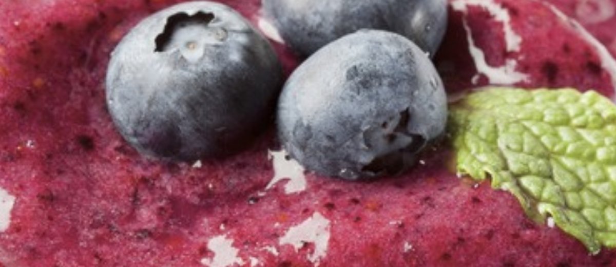 Dicker violetter Beeren-Smoothie mit Heidelbeeren und einem Minzblatt