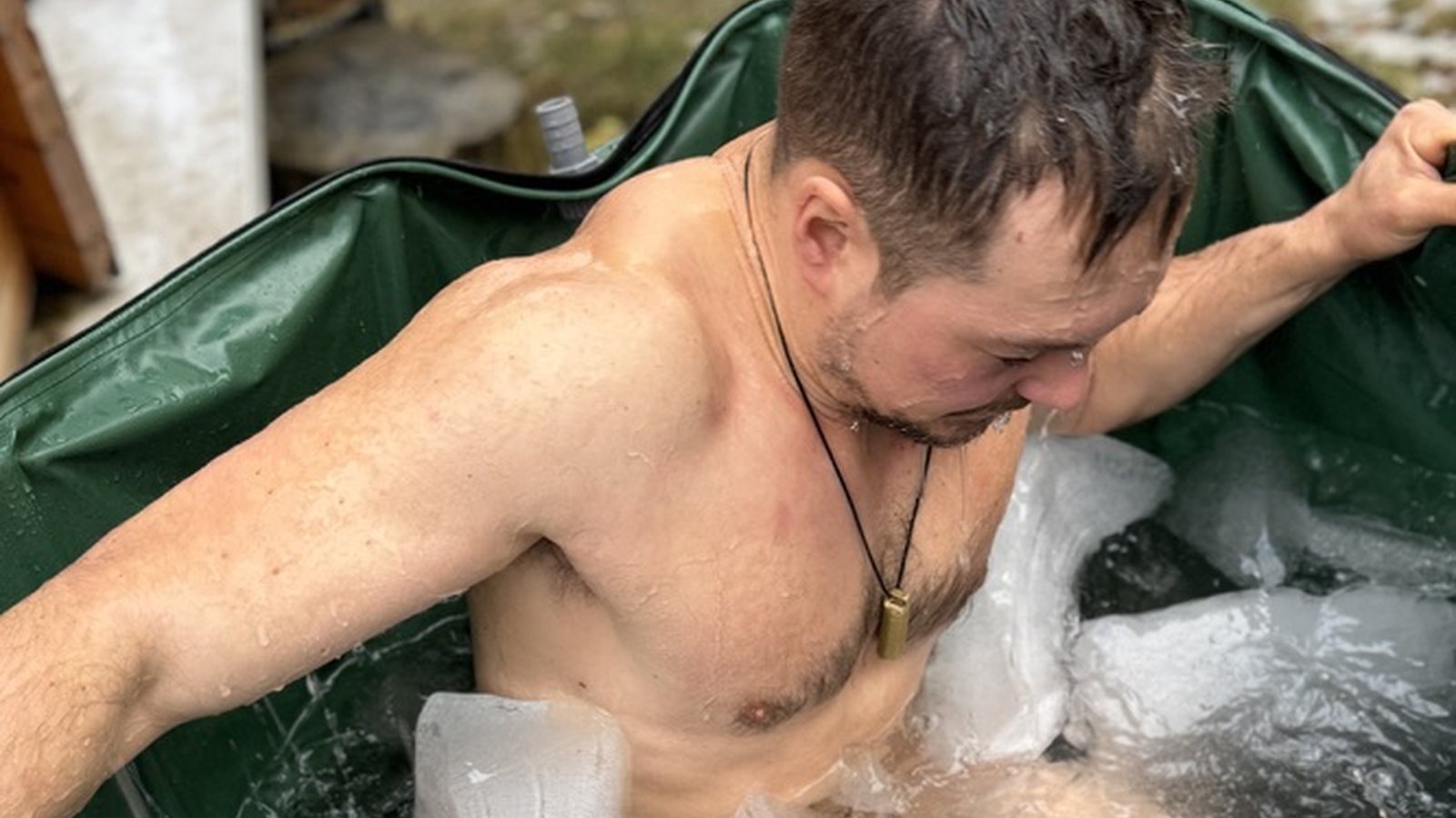 Tim sitzt im Eisbad zwischen Eisblöcken